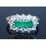 An 18ct yellow and white gold, emerald and diamond triple cluster ring, comprising three central