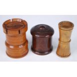 A 19th century turned boxwood castellated tower form money box, h.8cm, together with a treen