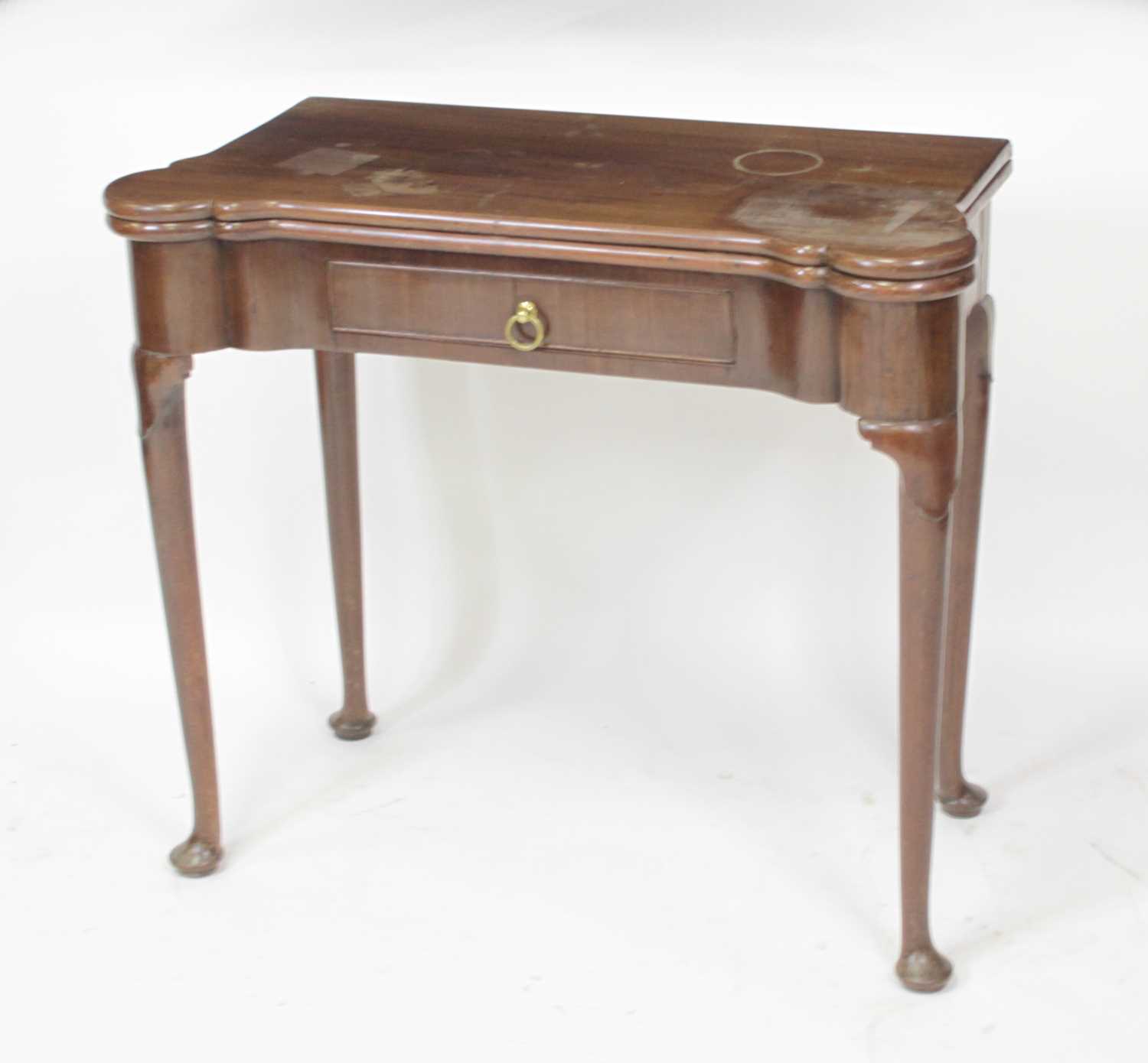 An early George III mahogany card table, the fold-over top with proud and dished corners, and