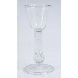 A wine glass, having a round funnel bowl above a teared baluster stem and folded foot, h.16cm