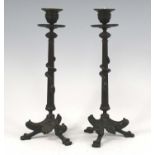 A pair of Egyptian Revival bronze candlesticks, the fluted columns each entwined with a snake, h.