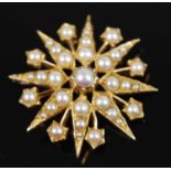 A late Victorian yellow metal seed pearl set sixteen ray star brooch, comprising 32 pearls with