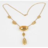 A yellow metal citrine multi-stone necklet, comprising six graduated oval and one pear shaped