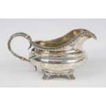 A 19th century silver cream jug, of squat circular form, having a gadrooned rim and standing upon