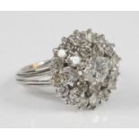A white metal diamond circular cluster ring, featuring a centre round brilliant cut diamond within