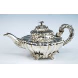 A George IV silver 'water-lily' teapot, of compressed melon form with applied leaf and lily cast
