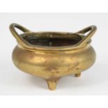 A Chinese gilt bronze tripod censer, having simple loop handles, the base with Xuande six