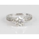 A contemporary white metal diamond solitaire ring, the four-claw set round brilliant weighing approx