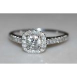 A white metal diamond cusion-shaped cluster ring, comprising a centre round brilliant cut diamond