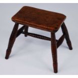 A 19th century provincial small stool / candle stand, the rectangular elm top raised on four ring
