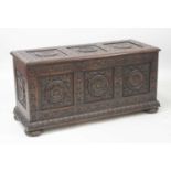 A late 19th century oak three-panel coffer, each panel carved with a central roundel within leaf and