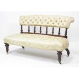 A Victorian walnut framed salon settee, the whole reupholstered in a buttonback silk damask, on ring