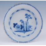 An English blue and white delftware charger, probably London, circa 1750, decorated with flowers and