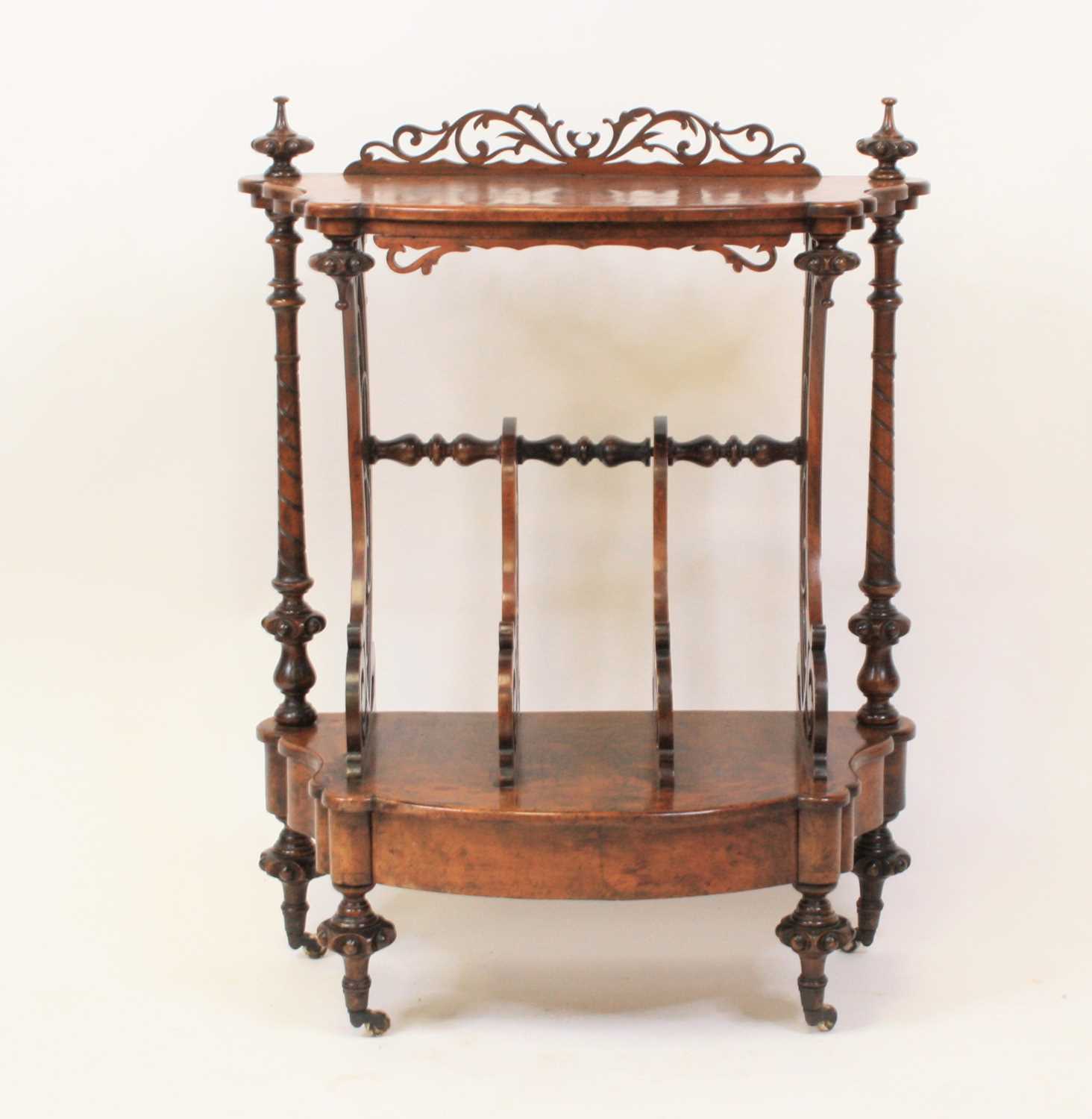 A mid Victorian walnut and figured walnut Canterbury whatnot of shaped outline with concealed base