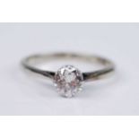 A white metal diamond solitaire ring, featuring a transitional round brilliant cut diamond in an
