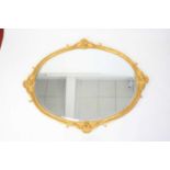 A Rococo Revival gilt wood and gesso framed and bevelled oval wall mirror, of good size, the