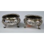 A pair of Victorian silver salts, of squat circular form, repousse floral embossed and with