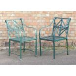 A pair of 19th century wrought iron garden open armchairs in the Regency taste, each having scroll