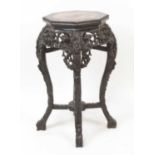 A Chinese carved rosewood jardiniere stand, of octagonal baluster form with marble inset top and