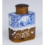 A Delft blue and white tea caddy, 19th century, decorated with a reclining lady, having Rococo style