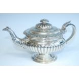 A George IV Scottish silver pedestal teapot, having leaf and flower cast rim over half-reeded