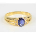 A yellow metal, sapphire and diamond ring, featuring a centre oval faceted sapphire in a four-claw