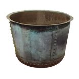 A circa 1900 extremely large copper log bucket of circular form with riveted construction, verdigris