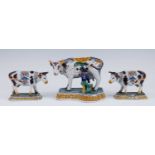 A pair of Royal Tichelaar Makkum Delft polychrome models of cows, early 20th century, each shown