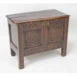 A 17th century joined oak two-panel coffer, of small proportions, having a two-plank hinged top with