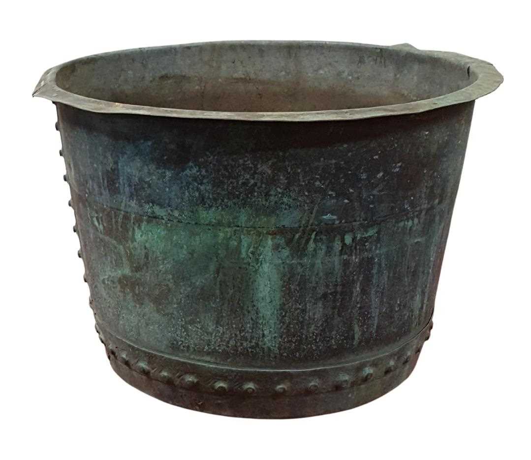 A circa 1900 large copper log bucket of circular form with riveted construction, verdigris patina,