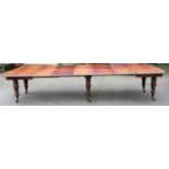 An early Victorian mahogany extending dining table, the top having pull-out action and five extra
