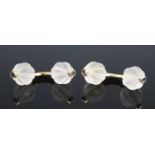 A pair of yellow metal curved bar cufflinks, each with a pair of carved rock crystal ball ends, with
