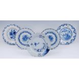 An English blue and white delftware plate, 18th century, decorated with flowers beside a fence,