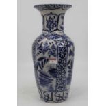 A large earthenware blue & white vase of baluster form, underglaze decorated with flowers & foliage,