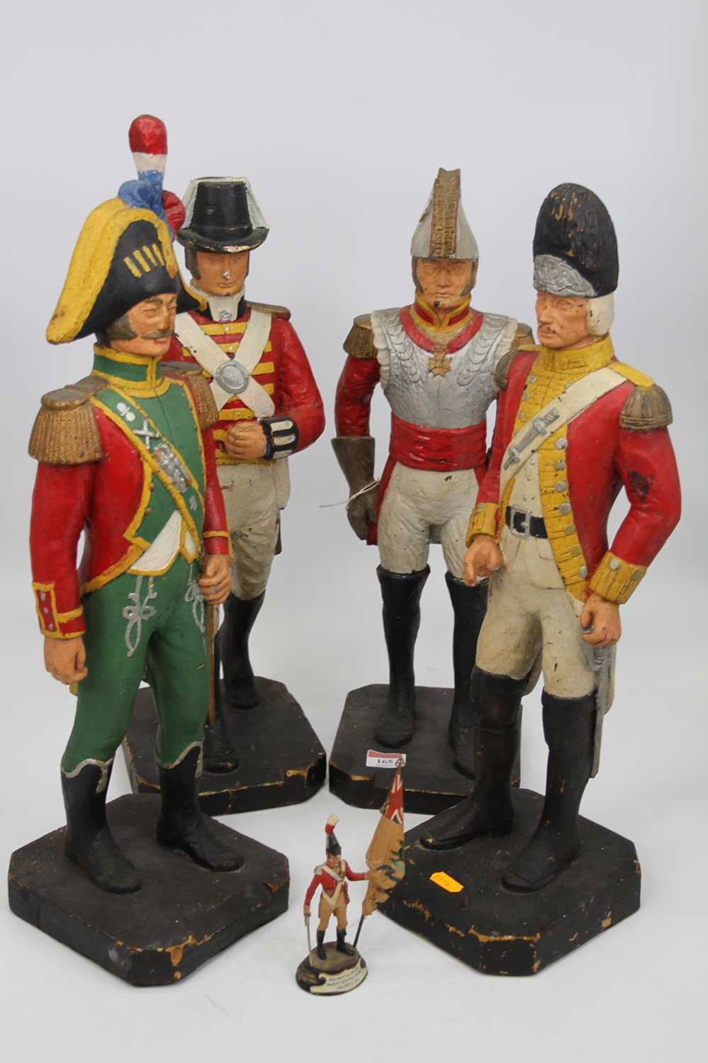 A set of four carved softwood and polychrome painted figures of soldiers, each in full military