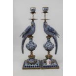 A pair of continental blue & white table candlesticks, each in the form of a bird perched upon an