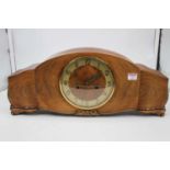 A 1950s walnut case mantel clock, the circular chapter ring with applied Arabic numerals and