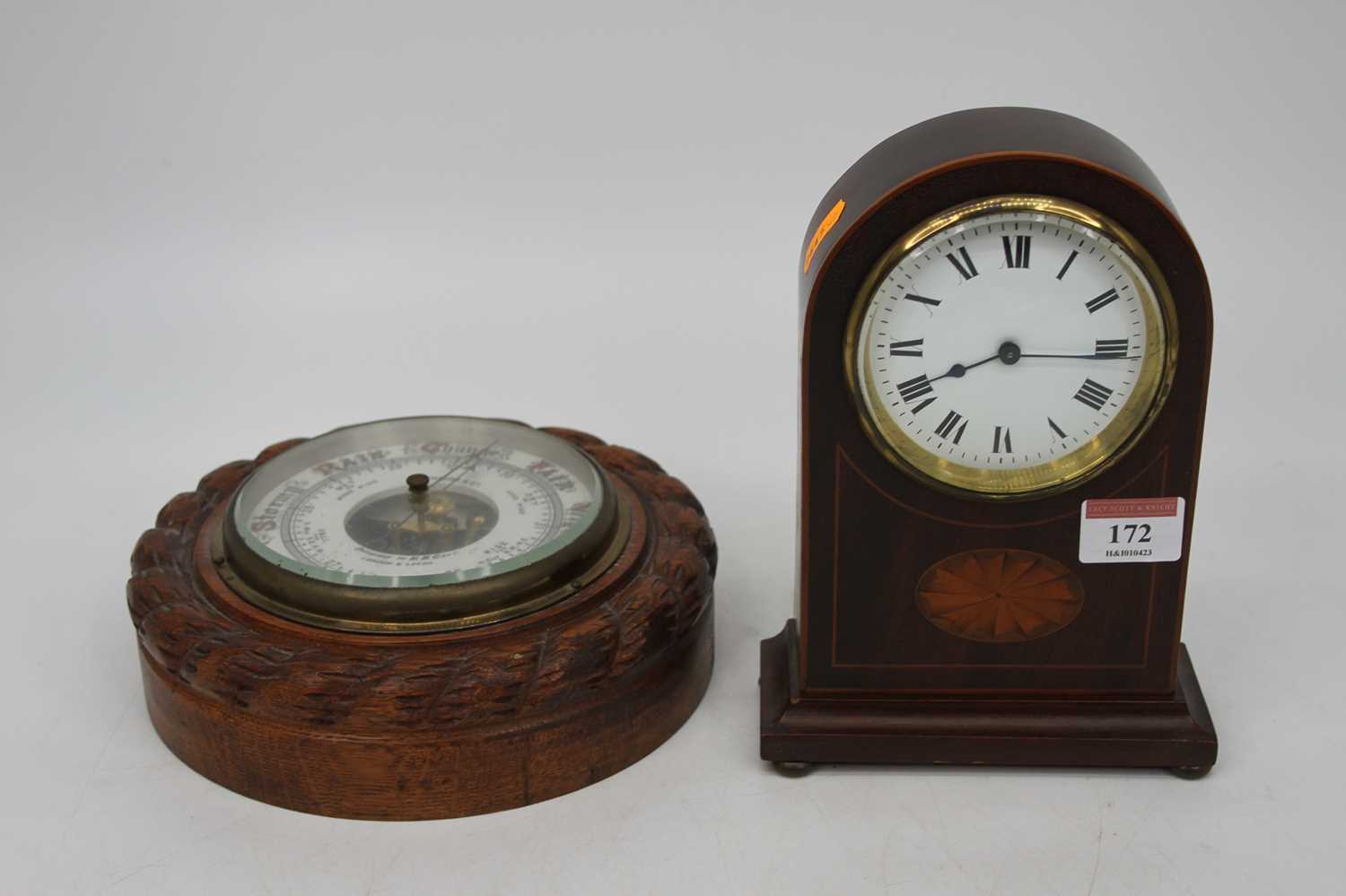 An Edwardian mahogany and boxwood strung dome topped mantel clock, having a convex enamel dial