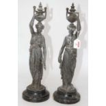 A pair of early 20th century spelter figures, each in the form of a Grecian watercarrier in standing