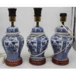 A set of three modern blue & white table lamps, each of baluster form on wooden base, height 33cm (