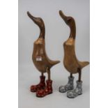 A pair of modern carved wooden figures of ducks in bright painted wellington boots, height 49cm