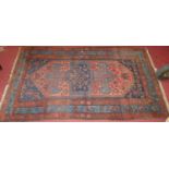 An Anatolian woollen rug, of red and blue ground, the central medallion within trailing tramline