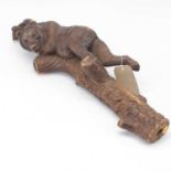An early 20th century Black Forest carving of a bear climbing a tree stump, 73cm (probably part of a