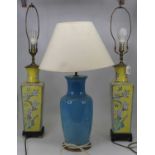 A pair of ceramic table lamps, each of square tapering form, decorated with birds and flowers on a