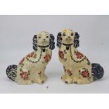 A pair of Staffordshire Siltone hand painted models of seated spaniels having printed mark verso,