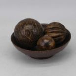 A 20th century turned beech shallow bowl, dia. 25cm, together with three carved wooden balls (4)