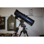 A Celestron Astro Master 130 telescope on adjustable tripod base