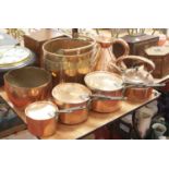 A graduated set of three 19th century copper saucepans, each having a cover with iron handle