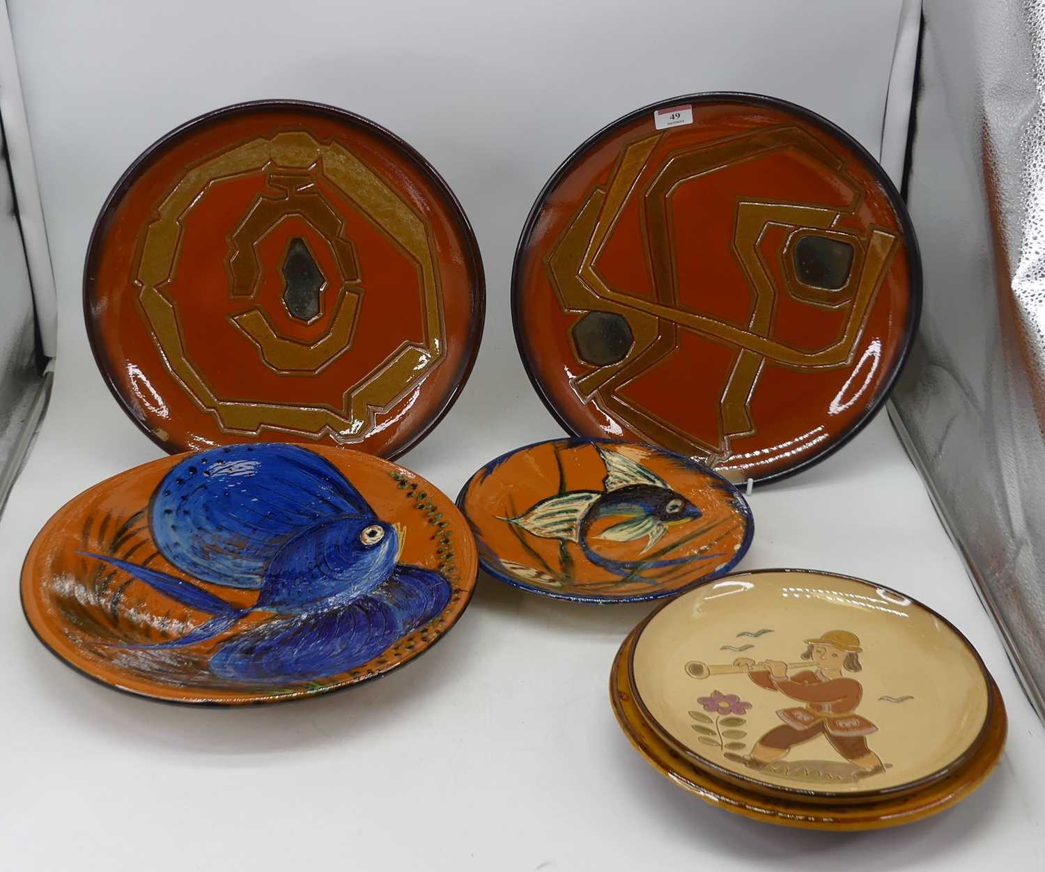 A 20th century continental studio pottery plate, incised with a musician, indistinctly signed verso,