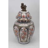 A large Japanese porcelain vase and cover of hexagonal baluster form, the cover surmounted by shi